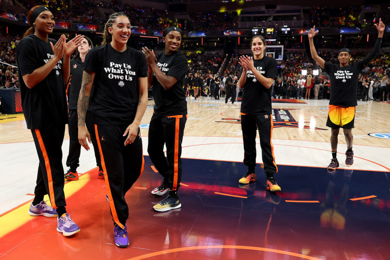  Kiki Iriafen #44 of the Washington Mystics, Gabby Williams #5 of the Seattle Storm, Jackie Young #0 of the Las Vegas Aces, Sonia Citron #2 of the Washington Mystics and Brittney Sykes #15 of the Washington Mystics wear shirts saying "Pay us what you owe us" prior to the WNBA All-Star Game on July 19, 2025 in Indianapolis, . 