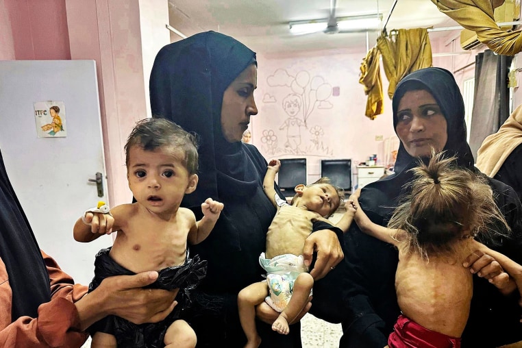 Mothers hold their emaciated children at Nasser Hospital in Khan Yunis, Gaza