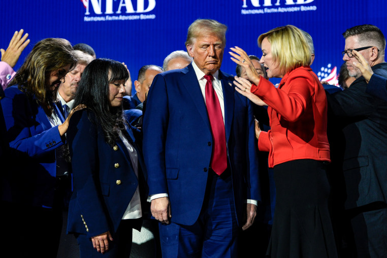President Donald Trump prays with Pastor Paula White and other faith leaders