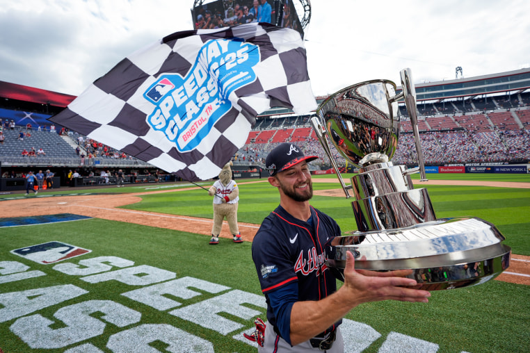 Eli White holds a trophy on the field