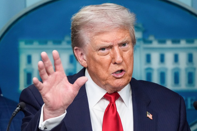Donald Trump speaks, one hand raised