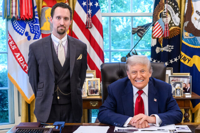 Economist E.J. Antoni stands, left, and President Donald Trump sits at his desk in the Oval Office