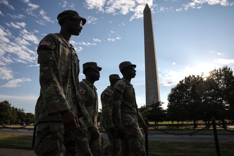 National Guard members walk outside near the Washington Monument