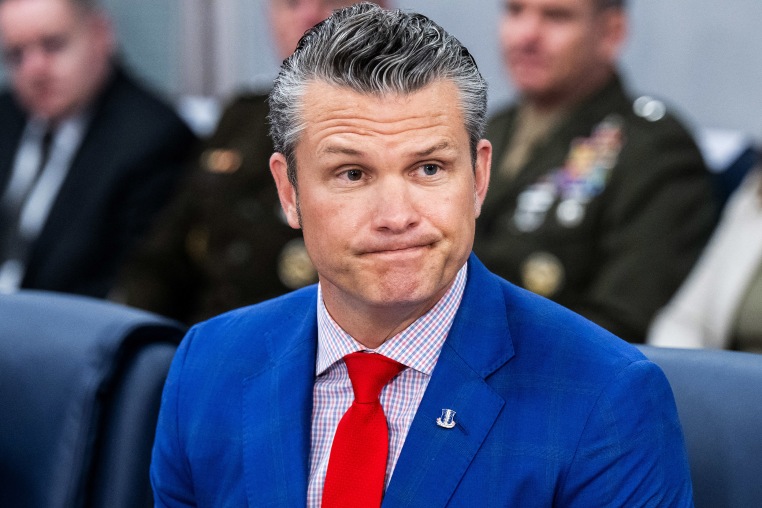 Pete Hegseth looks on during a meeting.