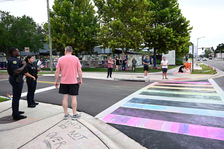 Orlando Police officers warn people not to apply chalk to the crosswalk outside of the Pulse Interim Memorial,