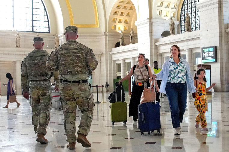 Travelers arrive alongside patrolling National Guard soldiers at Union Station on Aug. 25, 2025 in Washington, D.C. 