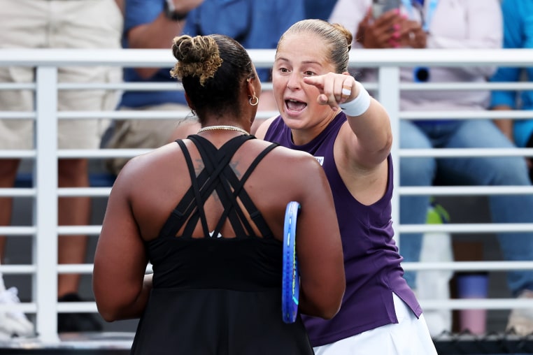 Jelena Ostapenko pointing at Taylor Townsend, who's back is facing the camera