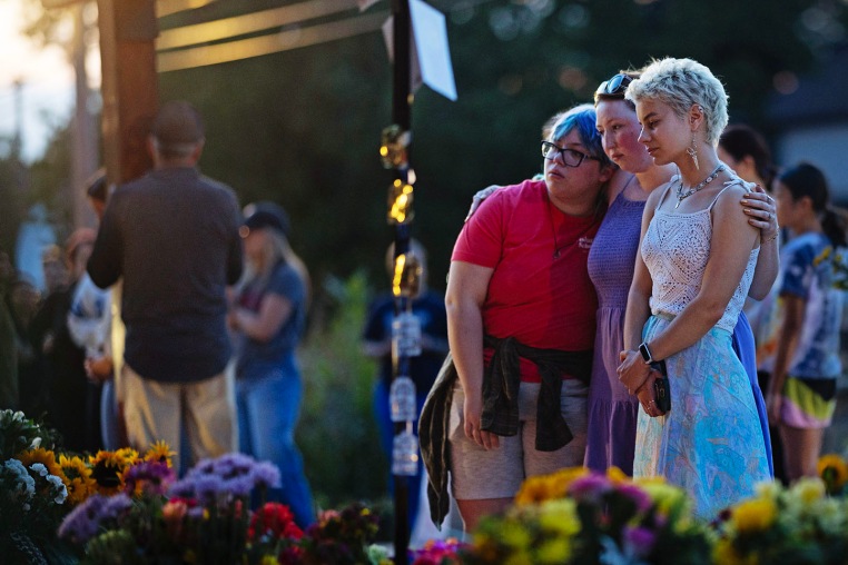 People gather at a memorial for victims of Wednesday's shooting in front of Annunciation Catholic Church 