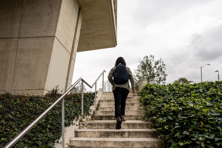 Rear view of a university student walking up the stairs