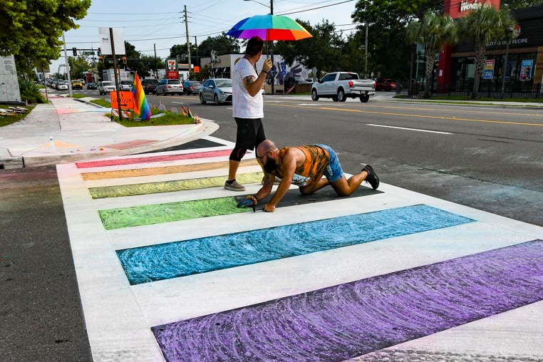 Activists use chalk to restore color to a rainbow crosswalk that the Florida Department of Transportation erased in Orlando, Fla.