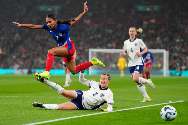 United States' Alyssa Thompson jumps over England's Lucy Bronze