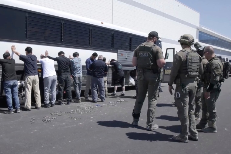 manufacturing plant employees waiting to have their legs shackled at the Hyundai Motor Group’s electric vehicle plant