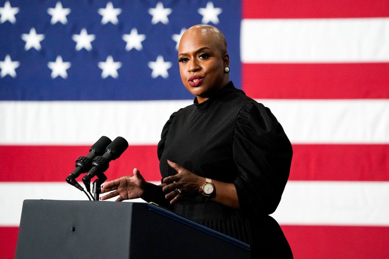 Ayanna Pressley speaks at a podium with an American flag backdrop