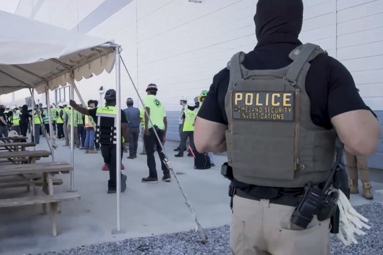 manufacturing plant employees being escorted outside the Hyundai Motor Group’s electric vehicle plant by officers