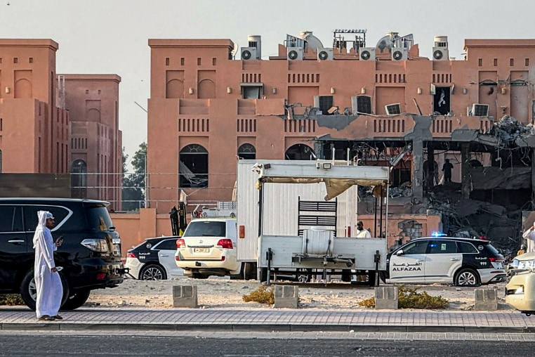 A man walks near a damaged building