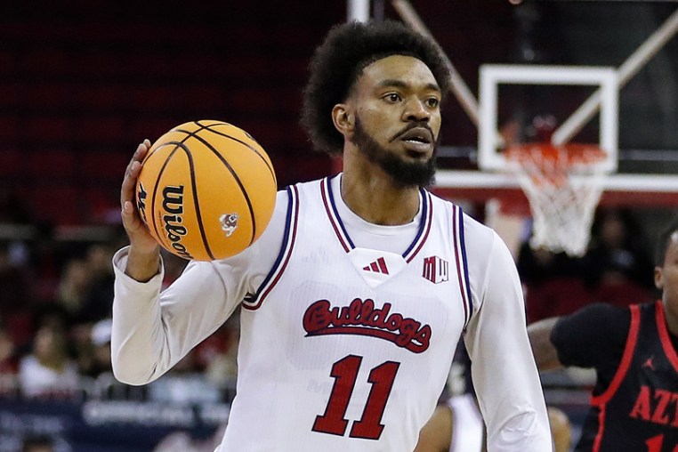 Mykell Robinson, center, holds a basketball while running on the court