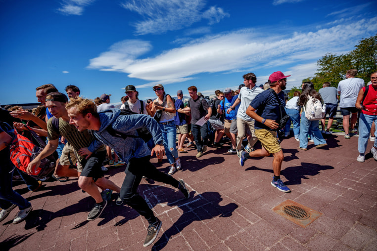 People run after a shot was fired at U.S. right-wing activist and commentator Charlie Kirk at a Utah Valley University speaking event in Orem