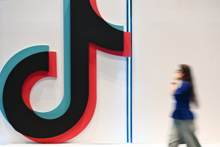 A person a phone next to Tiktok signage at a web summit.