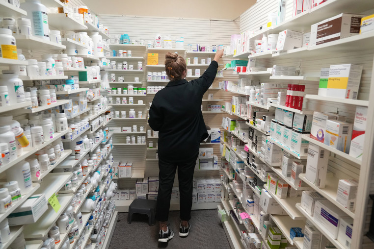 A pharmacy tech looks for a drug on a shelf at a pharmacy in Provo, Utah, on Aug. 7, 2025. 