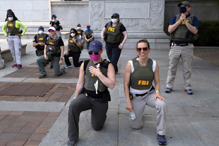 FBI officers take a knee with demonstrators as they march on Pennsylvania Ave in Washington, D.C., on June 4, 2020.