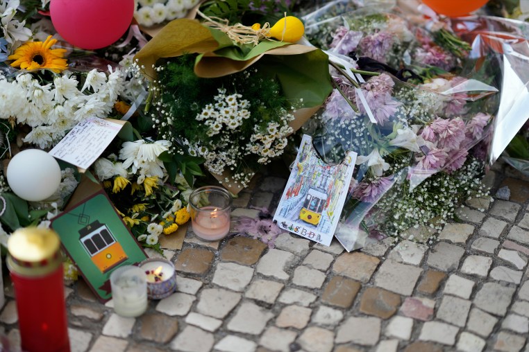 Postcards are placed among the flowers of a tribute to those that perished in the Gloria funicular, a tourist streetcar that derailed and crashed, in Lisbon, Saturday, Sept. 6, 2025.