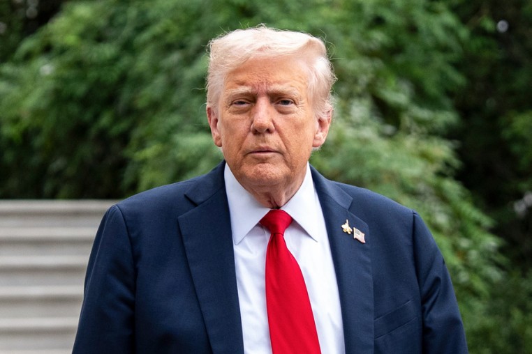 Donald Trump walks outside near a set of stairs