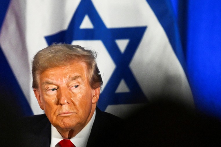 Donald Trump with the Israeli flag in the background.
