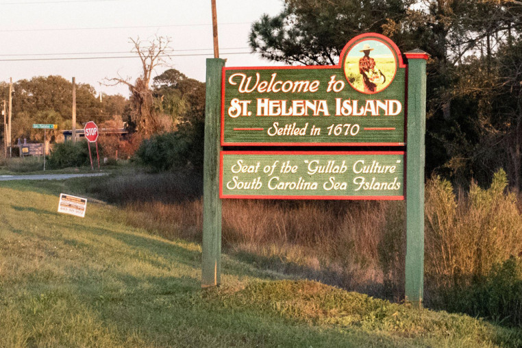 The sign for Saint Helena Island on the side of a two way road