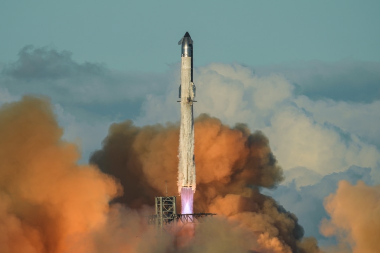 SpaceX's mega rocket Starship blasts off into the sky past clouds
