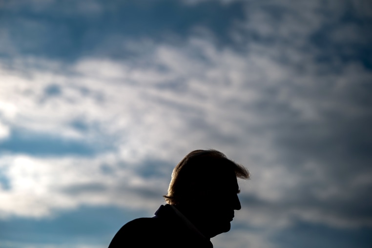 President Donald Trump against a cloudy sky.
