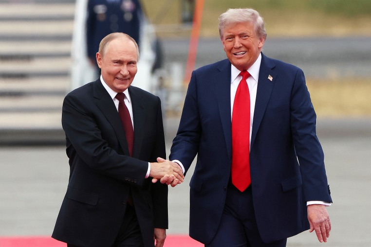 Donald Trump and Vladimir Putin shaking hands.