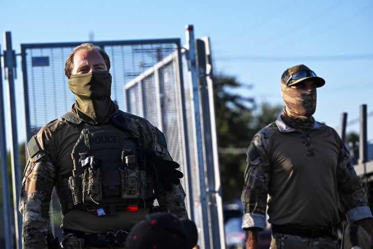 Federal Agents stand outside the Immigration and Customs Enforcement facility.