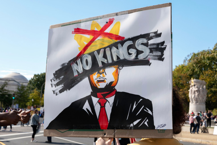 A protester holds a "No Kings" sign at a rally during a national day of protest.