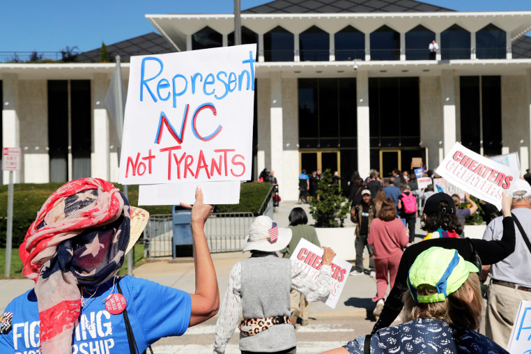 Demonstrators approach the Legislative Building during a rally protesting a proposed election redistricting map on Tuesday.