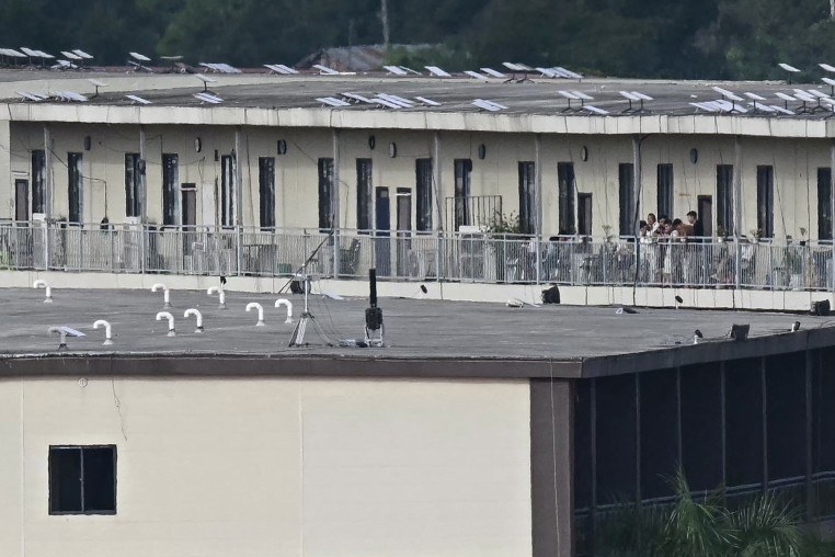 People on a balcony of a building with what appears to be Starlink satellite dishes