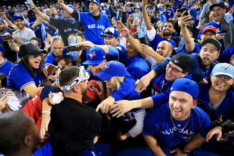 Marco Estrada #25 of the Toronto Blue Jays is swarmed by fans in Toronto, Canada.