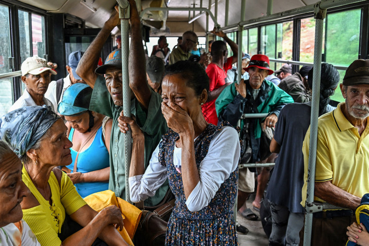 A woman reacts on the bus as residents are evacuated to safe locations ahead of the arrival of Hurricane Melissa.