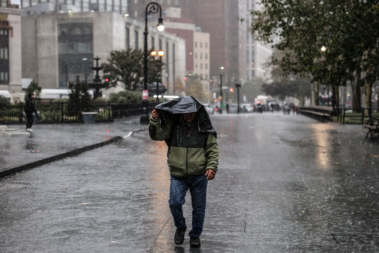 Image: A person walks in the rain