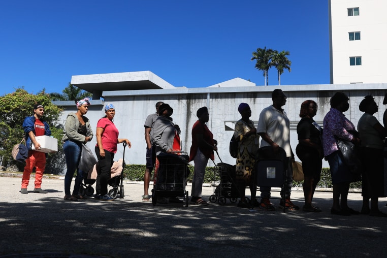 People waiting in line to receive groceries from Curley's House Food Bank.