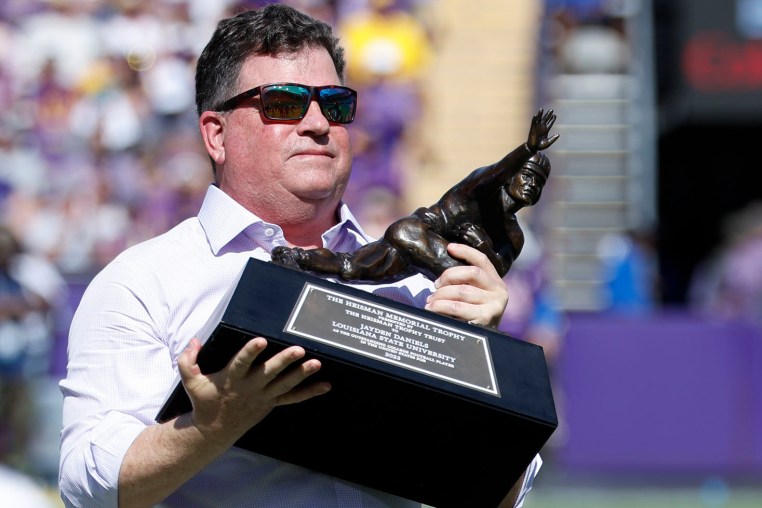 LSU athletic director Scott Woodward accepts a replica Heisman trophy for Jayden Daniels on Sept. 21, 2024, in Baton Rouge.