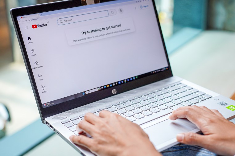 A woman browses Youtube website on her laptop.