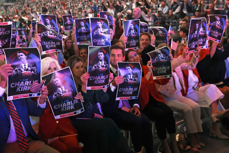 Attendees hold posters of late right-wing activist Charlie Kirk during a Turning Point USA.