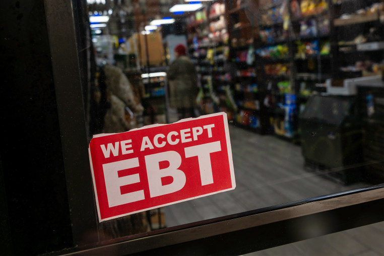 A store displays a sign accepting Electronic Benefits Transfer (EBT) cards for Supplemental Nutrition Assistance Program (SNAP) purchases.