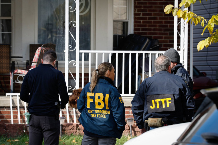 Members of the FBI Joint Terrorism Task Force stand in the front yard as they search a home in Dearborn, Mich., on Oct. 31, 2025. 