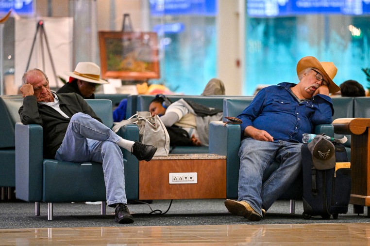 Travellers sleep on chairs during flight delays at Orlando International Airport in Florida on Oct. 30, 2025, after the Federal Aviation Administration (FAA) said the airport had no certified air-traffic controllers in its tower, forcing arrivals to be halted or severely delayed.