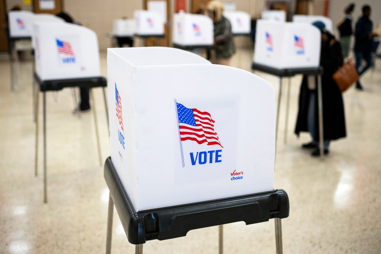 Voting booths and voters are seen on Election Day at a polling location.