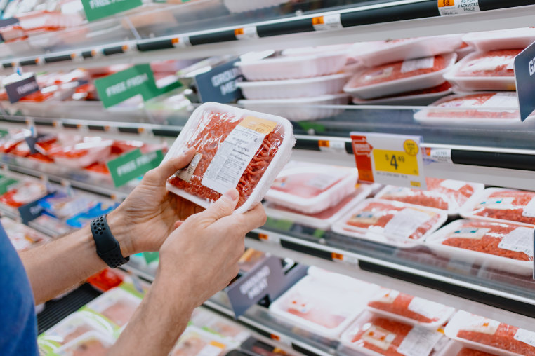 Man Checks Price of Ground Beef at Supermarket.