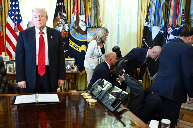 US President Donald Trump looks on after a man fainted during an announcement in the Oval Office.