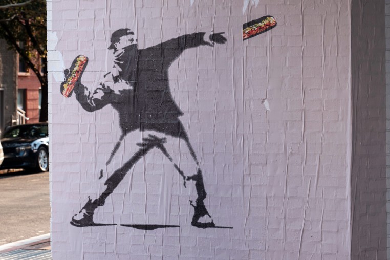 Banksy-style posters depicting a man throwing a sandwich in Washington, D.C.
