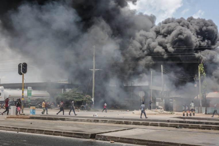 Protesters gather near burning buildings and barricades as clashes erupt in Dar es Salaam on Oct. 29 during Tanzania's presidential elections.